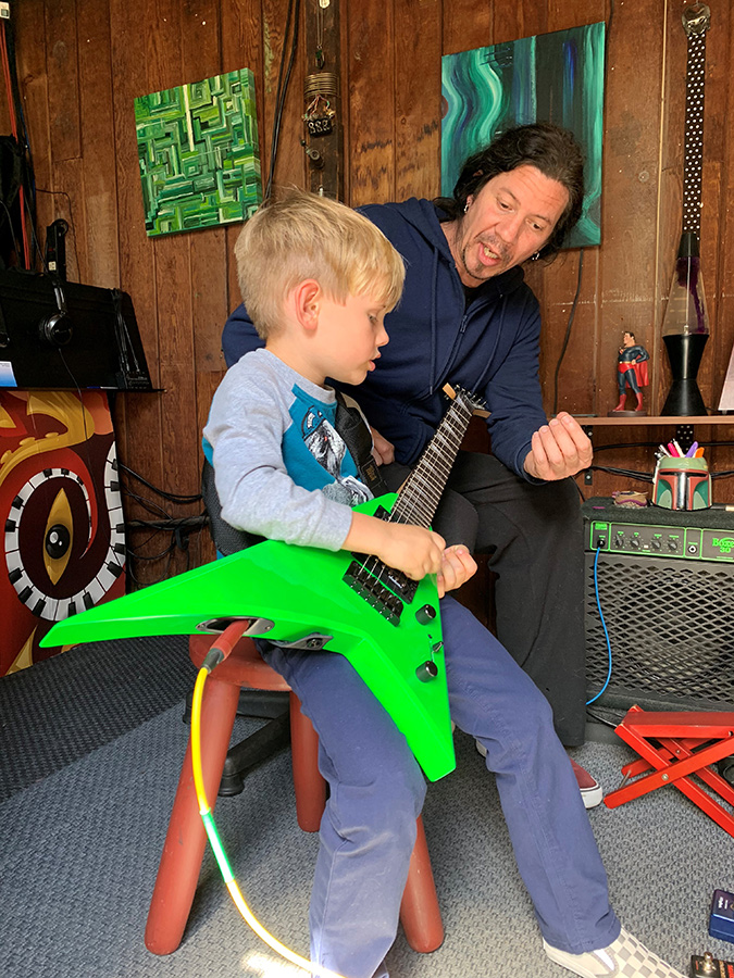 Mike Ruggirello teaching guitar to a young student